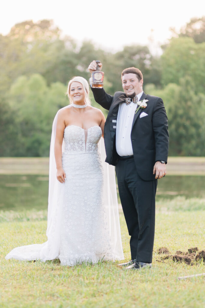 Digging up a bottle of Jack Daniels bourbon during the southern tradition of "burying the bourbon". 