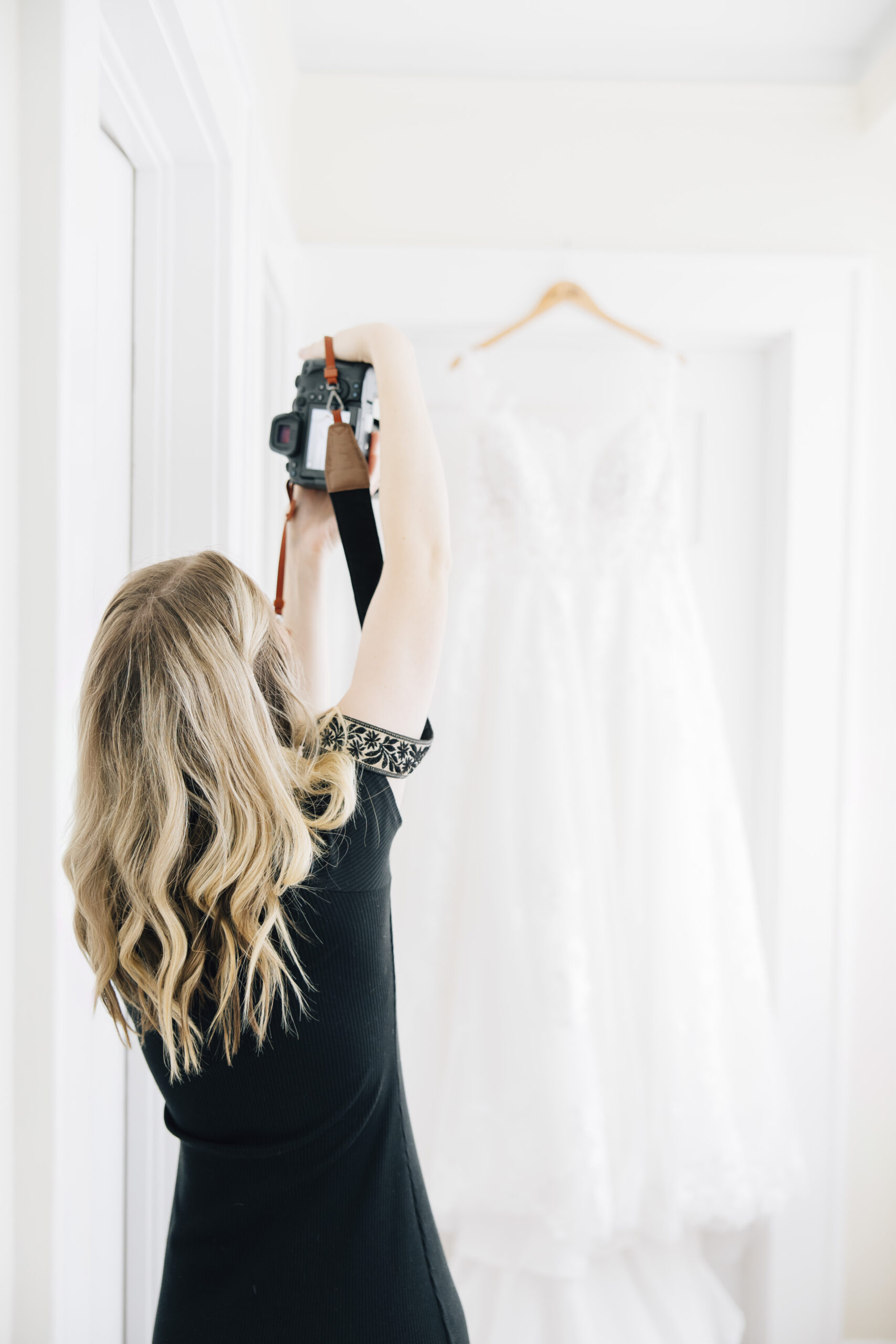 Elizabeth Godwin Photography holds her camera to capture a bride's wedding dress at a plantation venue in Valdosta, Georgia.