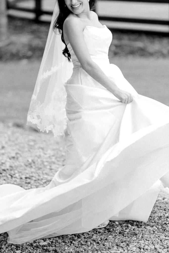 A beautiful fine art black and white image of a bride spinning in her wedding dress. 